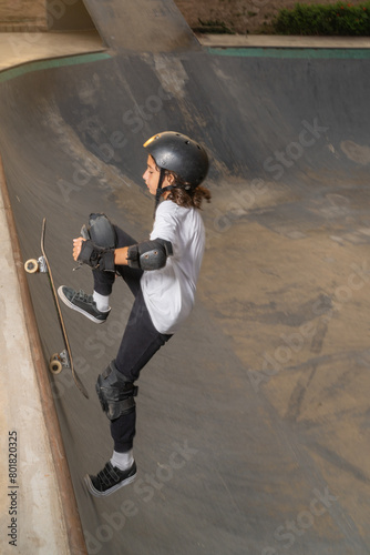 Boy riding his skateboard up the ramp at the skateboard park