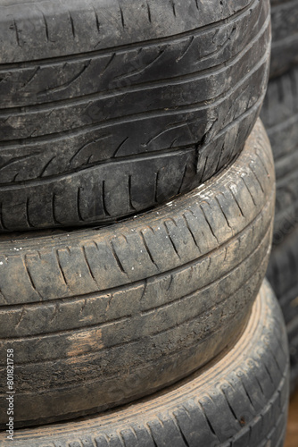 Old tires stacked in a heap, black rubber patterns, auto recycling