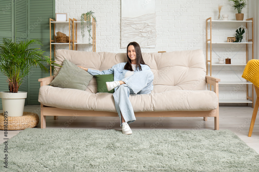 Young woman resting on sofa in living room Young woman resting on sofa in living room