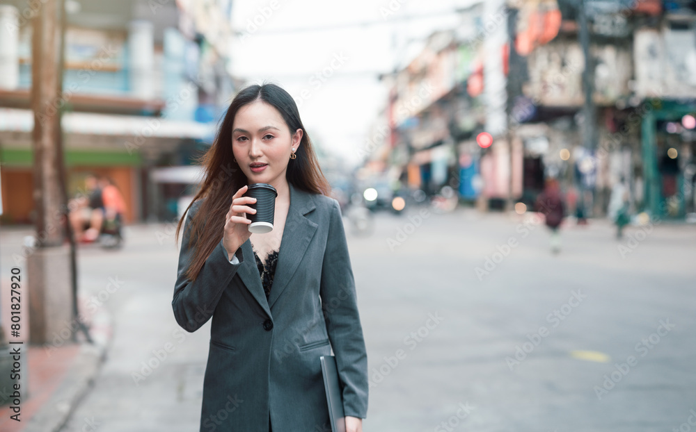 Beautiful woman going to work, businesswoman holding laptop with a cup of coffee