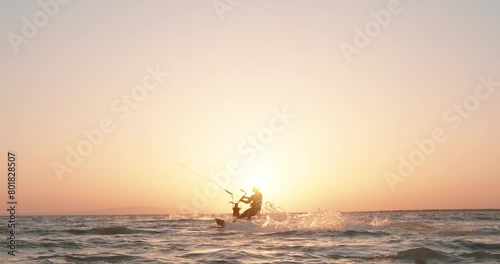 Kite surfers riding kite surf at sunset. Kitesurfing silhouette view. Extreme watersport activity