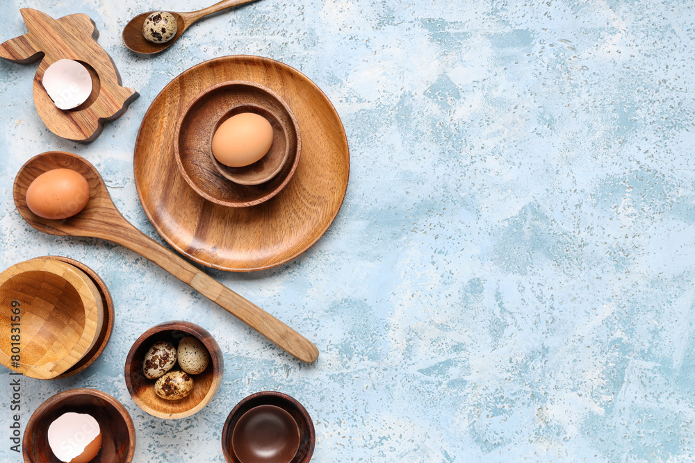 Stylish table setting with Easter eggs and wooden bunny on blue grunge background Stylish table setting with Easter eggs and wooden bunny on blue grunge background