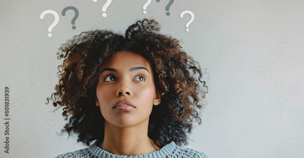 Woman thinking with question marks floating above her head on light ...