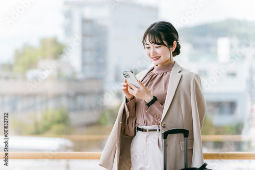 駅・ターミナルのエントランスにいる女性（待ち合わせ・デート・観光・旅行・スマホ・アプリ））
 photo