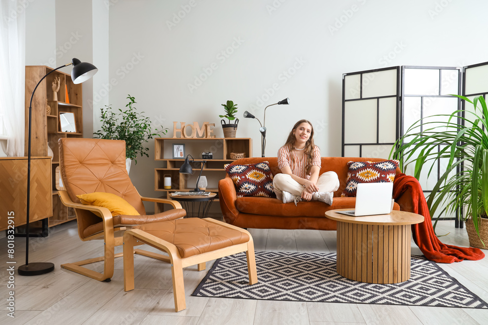 Young woman sitting on red sofa at home Young woman sitting on red sofa at home