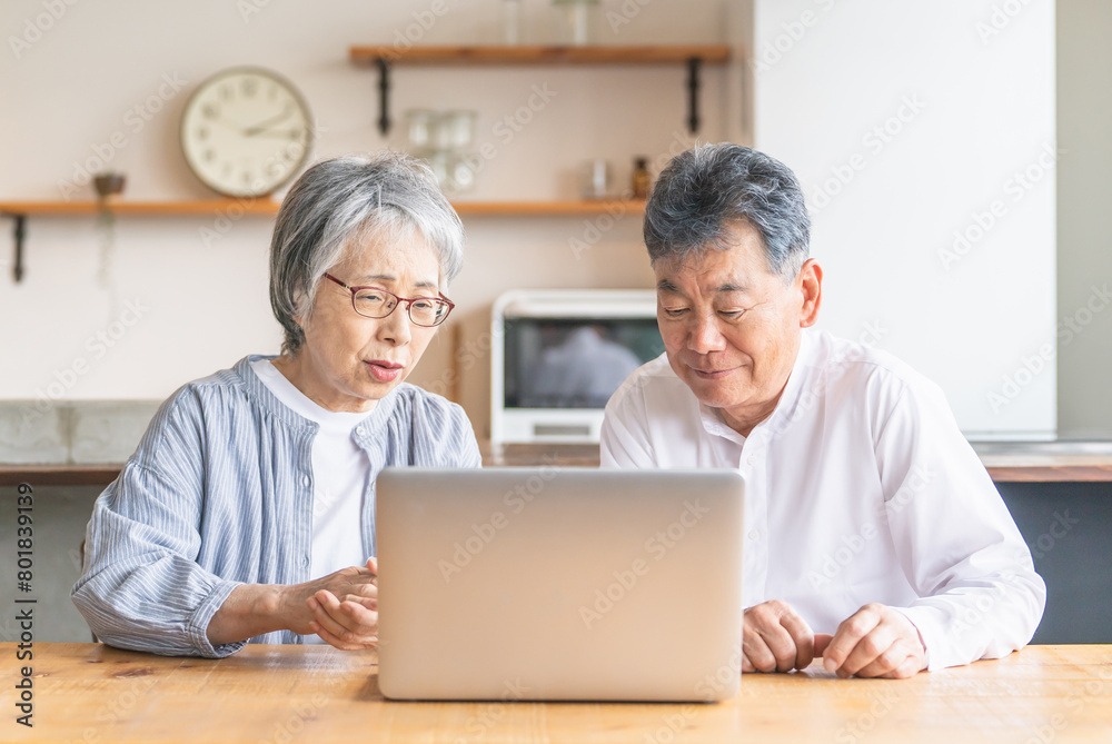 自宅でノートパソコンを使用中に悩むシニア夫婦（わからない・トラブル・詐欺・困る・心配・不安）
