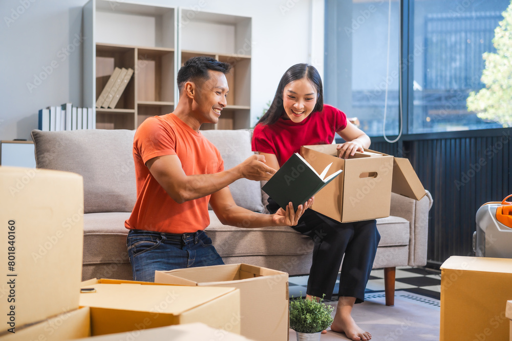 Young Asian couple relocating to a new house, joyfully packing and unpacking belongings. Expertise in moving, packing, togetherness, and creating a new home together. Young Asian couple relocating to a new house, joyfully packing and unpacking belongings. Expertise in moving, packing, togetherness, and creating a new home together.