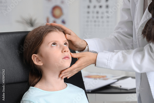 Female ophthalmologist examining little girl s eyes in clinic  closeup