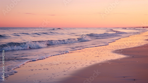 A serene beach scene at sunset  with waves gently lapping against the shore and the sky painted in hues of orange  pink  and purple