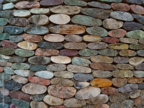 Cut pebble stone texture wall floor colorful background. Wall made from cut pebble gravel stones different shape as floor texture background. Multicolor sliced pebble cut stones wall. Cut stone wall photo
