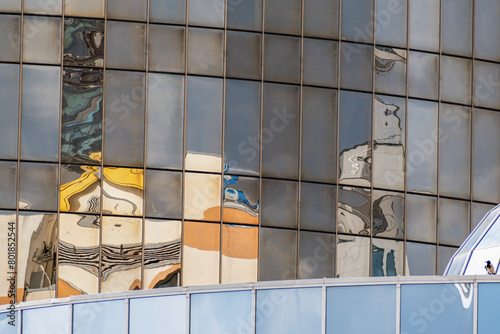 Reflection in the glass wall of the urban landscape on a spring day