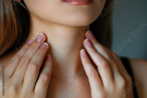 Woman's hands touch her neck. Concept of thyroid disease or sore throat. photo