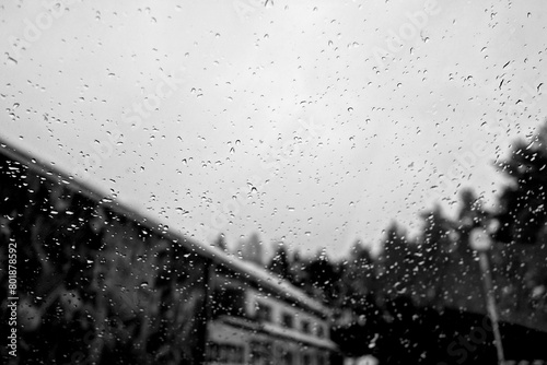 View on winter city wet windshield with rain drops. Black and white