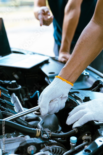 Auto mechanic working on car engine