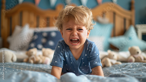 children's bad sleep. A 4-year-old boy screams against the background of a children's bedroom. toddler having a temper tantrum in their bedroom. The little boy is angry.  photo