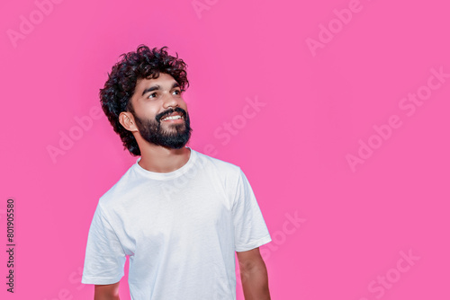 Handsome joyful smiling young indian man looking aside up and straight thinking of new good opportunities, dreaming, feeling inspired and proud standing isolated on pink background. Portrait