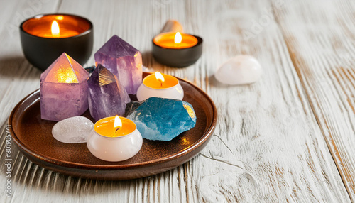 A set of esoteric healing crystals on a plate with candles  copy space on a side