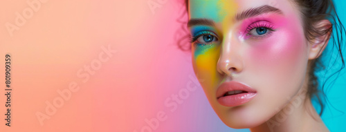 A woman with colorful makeup on her face. The background is a bright pink and blue color. colorful make up concept