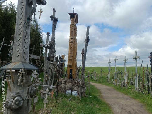 Hill of crosses. Crosses and rosemary on hill. Small hill. Loads of crosses. Few trees. Sunny day. Summer season. Monument. Siauliai. Kryziu kalnas Siauliuose. photo