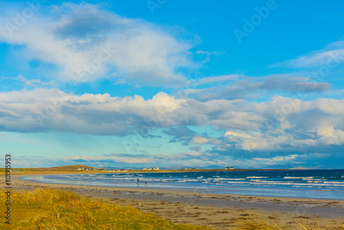 Gott Bay, Isle of Tiree, Inner Hebrides, Scotland in Springtime with whitewashed cottages, blue sky, machair, and a choppy sea. Hoirzontal.  Space for copy photo