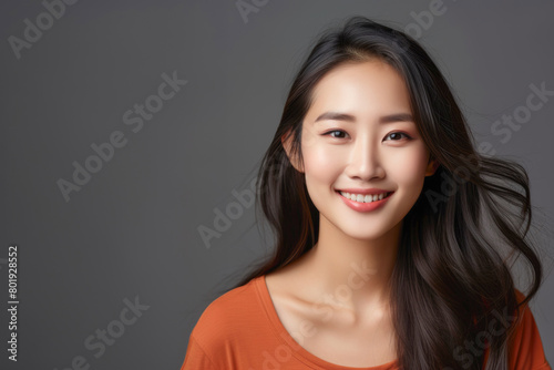 Gorgeous young asian woman in an orange top smiling