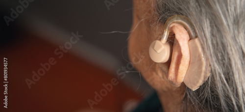Caucasian elderly woman with a hearing aid in ear. © andranik123