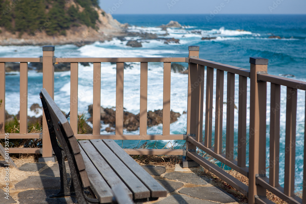 View of the empty wooden bench on the cliff at the seaside View of the empty wooden bench on the cliff at the seaside