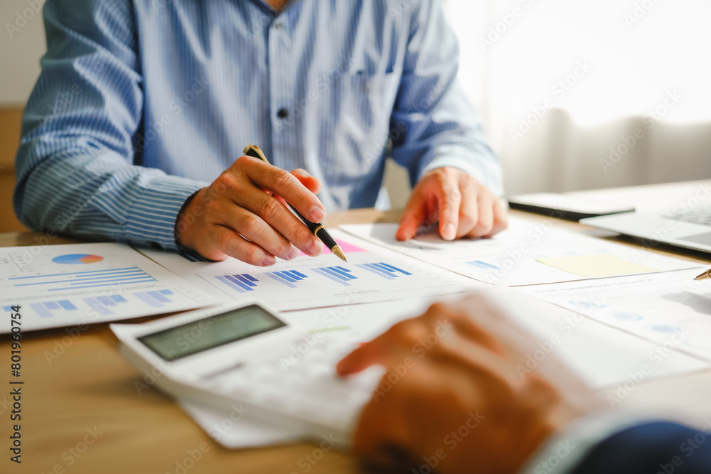 Desk-bound businessman calculates figures, verified accounts, and collaborates in discussions. Proficient in using calculators, aiding each other, and managing annual tax accounts in the audit office Desk-bound businessman calculates figures, verified accounts, and collaborates in discussions. Proficient in using calculators, aiding each other, and managing annual tax accounts in the audit office