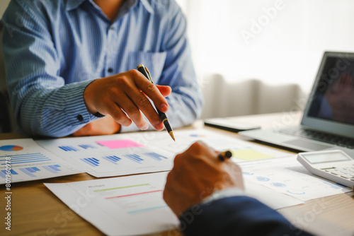 Desk-bound businessman calculates figures, verified accounts, and collaborates in discussions. Proficient in using calculators, aiding each other, and managing annual tax accounts in the audit office