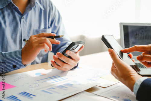 Desk-bound businessman calculates figures, verified accounts, and collaborates in discussions. Proficient in using calculators, aiding each other, and managing annual tax accounts in the audit office photo