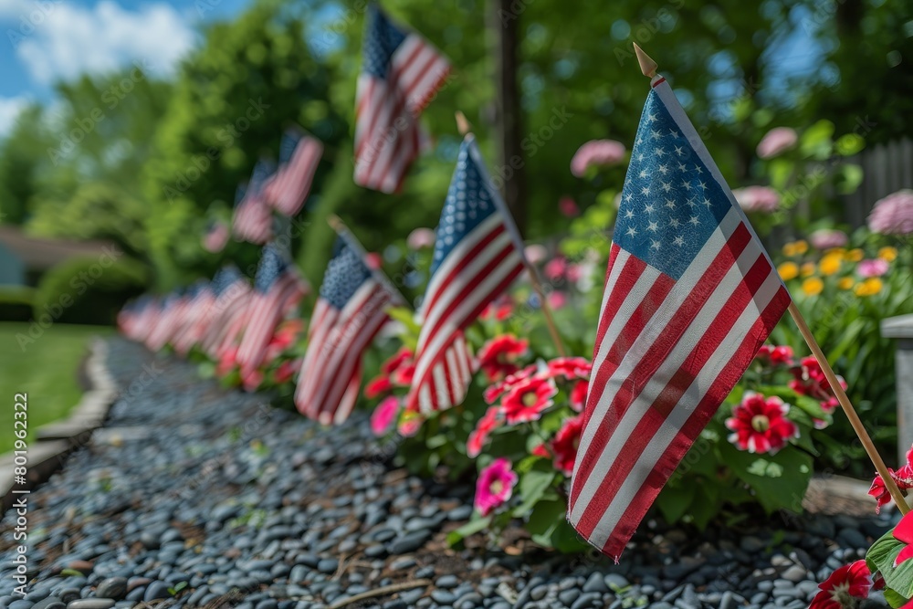 A row of American flags are planted in a garden A row of American flags are planted in a garden