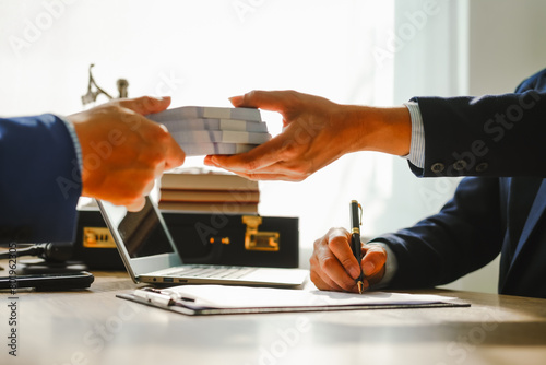 Legal expert navigating corruption cases, including bribery and graft. Businessman consults at desk. Discussions involve bribery, corruption, buying off, and corrupt practices.