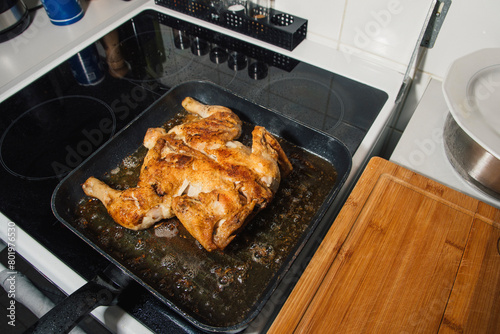 The chicken is browned in a frying pan. Chicken is cooking on the stove.