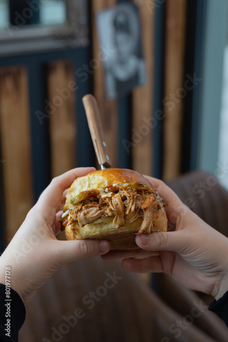 pulled pork hamburger in hand  photographed close up