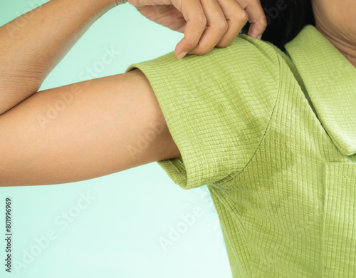 Woman Hyperhidrosis Wet Green shirt Underarm Hand Close Up. Problem Armpit Sweat Stains and Strong Body Odor,Hyperhidrosis Sweating,Hygiene for Good Health Concept,Sweaty Under Arm.