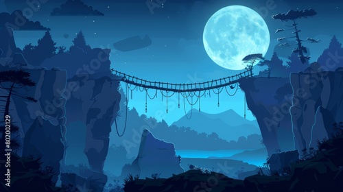 At night, a rope bridge crosses a gap chasm in a dangerous rock cliff. The landscape is a dark evening cartoon with an adventure footbridge over canyons in the mountains lit by the moonlight. photo