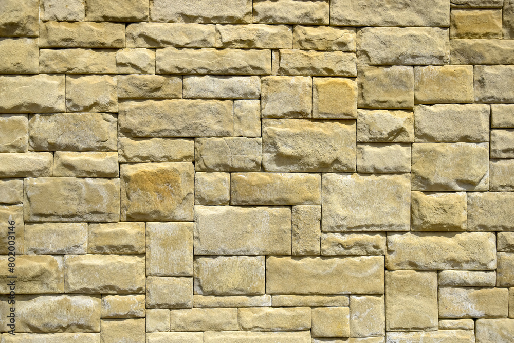 Abstract geometric background of wall lined with yellow decorative stone tiles. Close up. Abstract geometric background of wall lined with yellow decorative stone tiles. Close up.