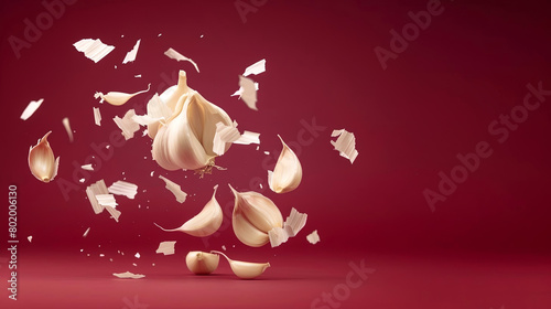 Captivating image of garlic cloves suspended in mid-air against a rich red backdrop