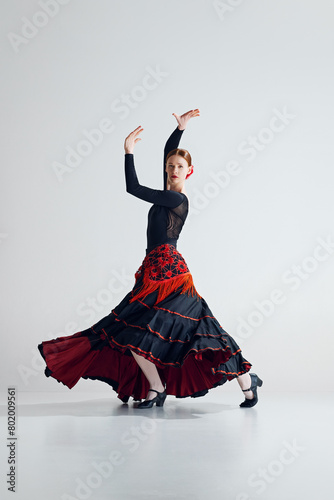 Flamenco female dancer in full motion performing with grace and intensity, highlighting dynamic spirit of flamenco dance. Concept of art of movement, classical dance, beauty, festival