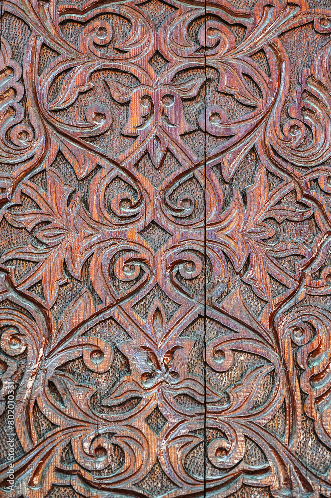 Oriental Uzbek Islamic kandakori patterns arabesque ornament on an ancient wooden carved door in Uzbekistan close-up