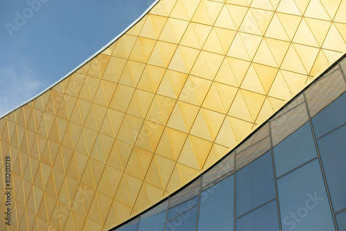 Modern building made of glass and metal. Golden color in architecture of building. Modern style of building.
