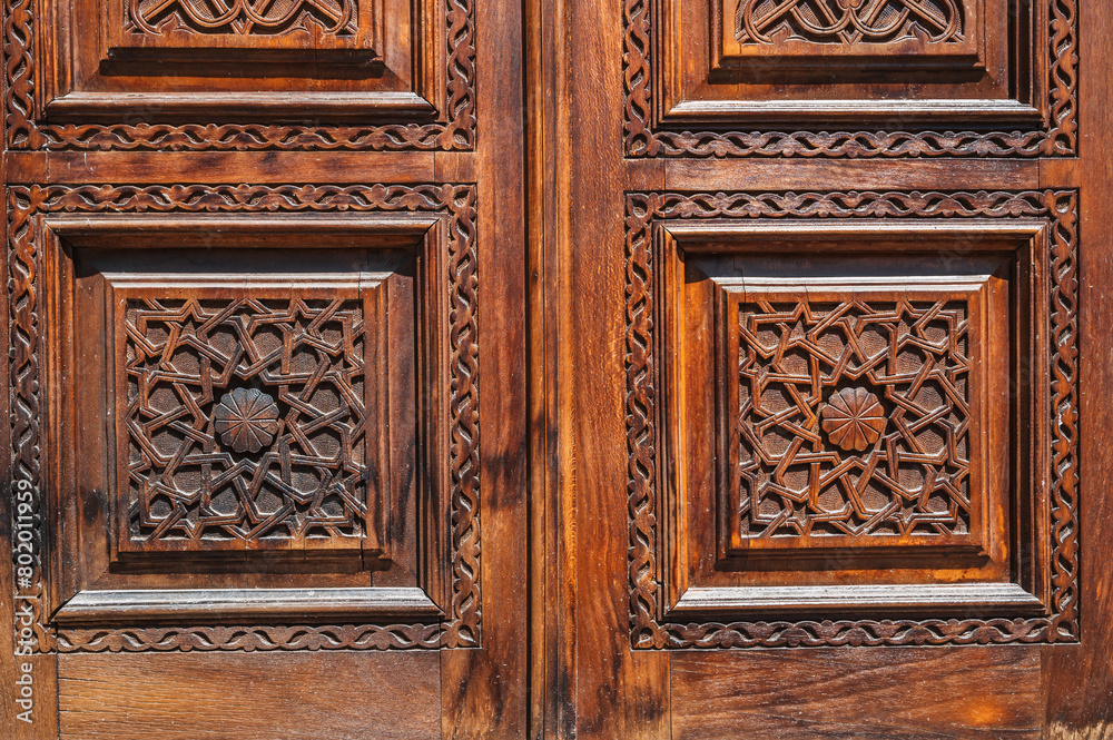 Oriental tajik Islamic kandakori patterns arabesque ornament on an old wooden carved door in Tajikistan close-up Oriental tajik Islamic kandakori patterns arabesque ornament on an old wooden carved door in Tajikistan close-up