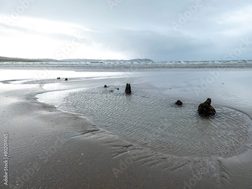 The remains of the unknown shipwreck become visible during the storm at Dooey beach by Lettermacaward in County Donegal - Ireland