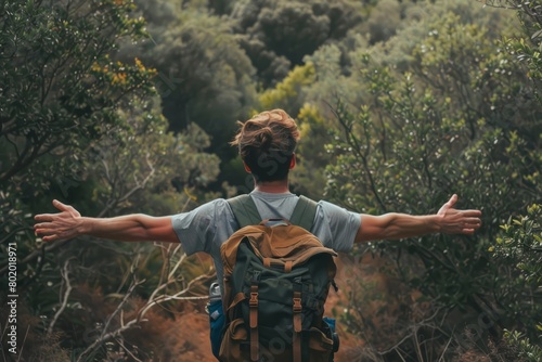 A Solo traveler backpacker opening his arms arriving at the forest,, embracing the nature, enjoying the travel, travelers life photo