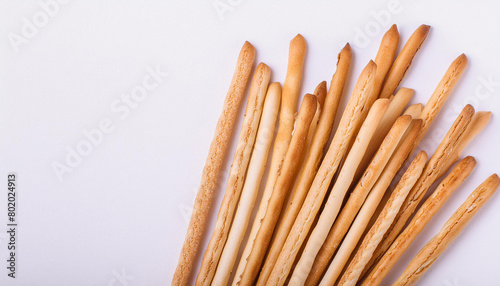 Freshly baked breadsticks on white table. Tasty food. Delicious snack. Baked goods. Top view.