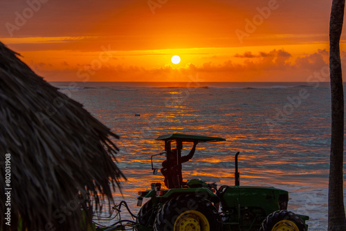 Superb sunrise on a pretty beach with tractor in Punta Cana in the Dominican Republic