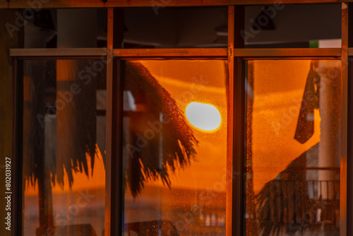 Reflection of a stunning sunrise in the window of a restaurant on the beach in Punta Cana
