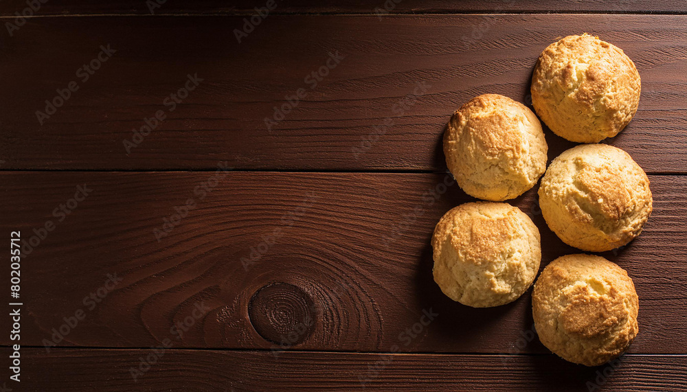 Freshly baked buttermilk biscuits on brown wooden table. Tasty cookies. Delicious snack. Top view Freshly baked buttermilk biscuits on brown wooden table. Tasty cookies. Delicious snack. Top view
