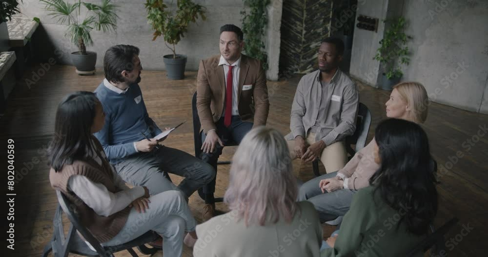 Unhappy person sharing problems with diverse group of people opening up at therapy session in rehab while patients expressing support