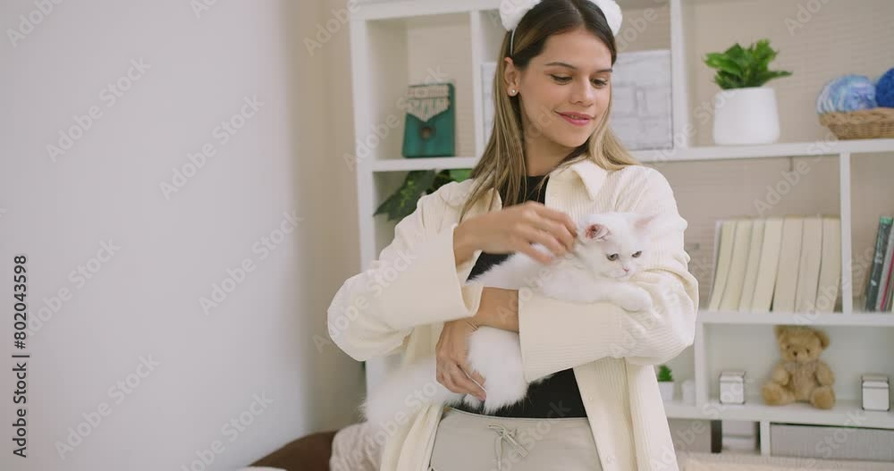Cute pretty young beautiful woman is holding hugging embrace cute little fluffy a white cat in her arms. The woman is smiling and seems to be enjoying the moment, Relationship between pets and people Cute pretty young beautiful woman is holding hugging embrace cute little fluffy a white cat in her arms. The woman is smiling and seems to be enjoying the moment, Relationship between pets and people